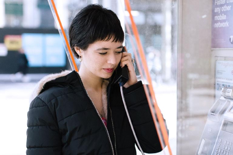 Woman speaking on the telephone in a phone booth